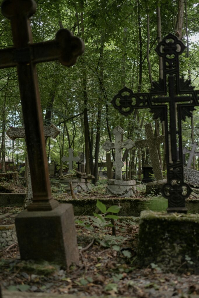 Peaceful cemetery with crosses surrounded by lush trees, capturing a serene outdoor nature setting.